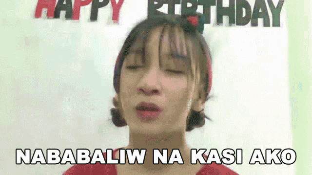 a woman is blowing a kiss in front of a sign that says happy birthday