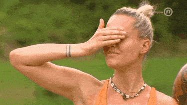 a woman covering her face with her hand with the letters n on the bottom right
