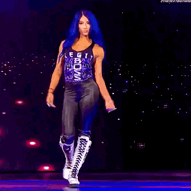 a woman with blue hair is dancing on a stage wearing knee pads and boots .