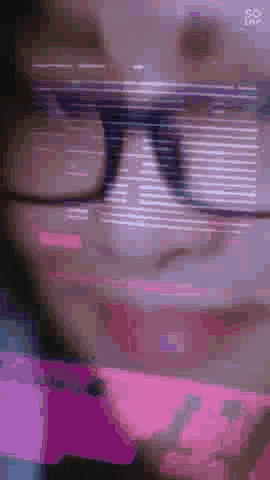 a close up of a person wearing sunglasses and a pink shirt .