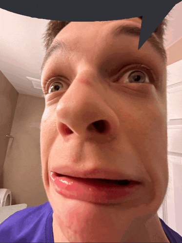 a close up of a man 's face with a blue speech bubble above his head