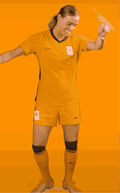 a female soccer player wearing a yellow jersey with the number 10 on the front