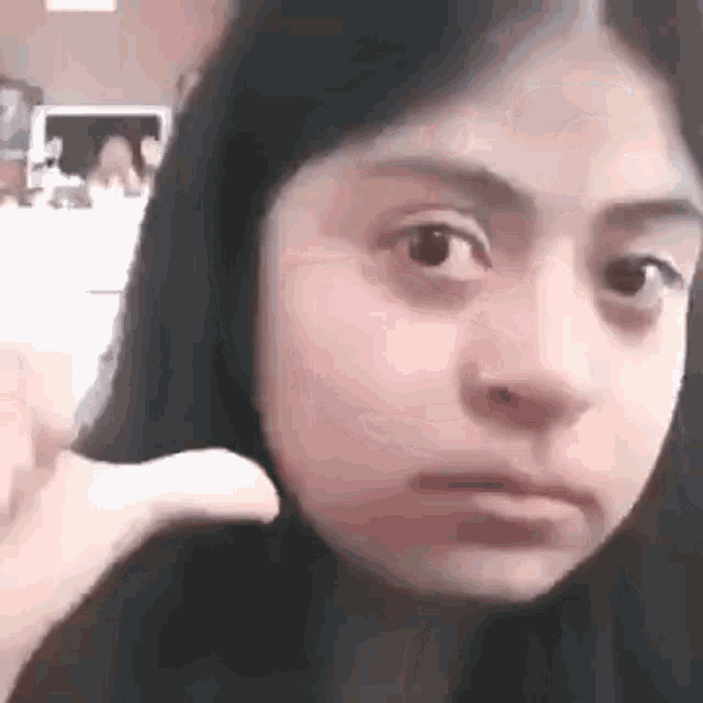 a close up of a girl making a funny face with her hand on her forehead .