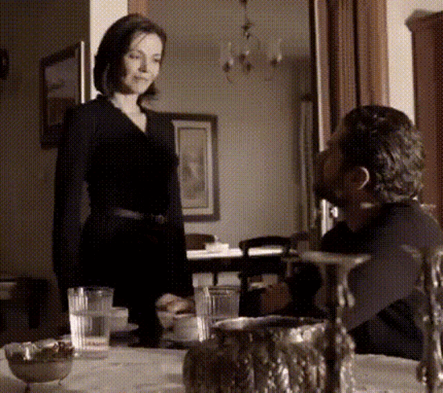 a woman in a black dress is standing next to a man in a black suit