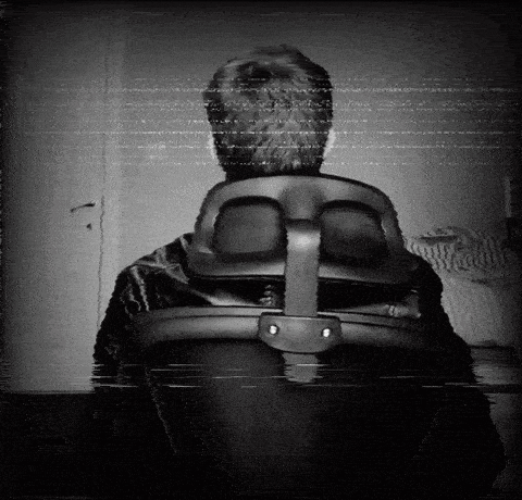a black and white photo of a man in an office chair