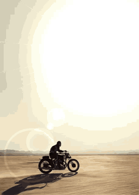 a person riding a motorcycle in the desert