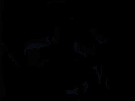 a man is singing into a microphone in a dark room