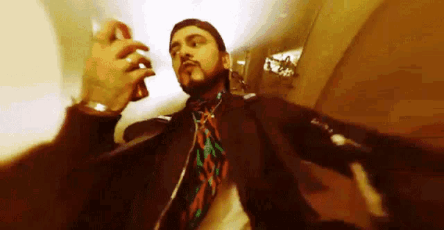a man with a beard holds a can of soda