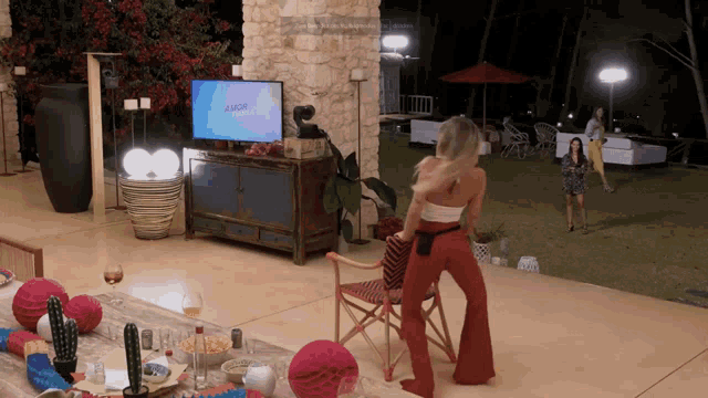 a woman is standing in front of a television that says amor