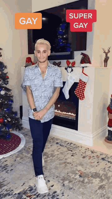 a man is standing in front of a fireplace with a christmas tree and stockings hanging on the mantle ..