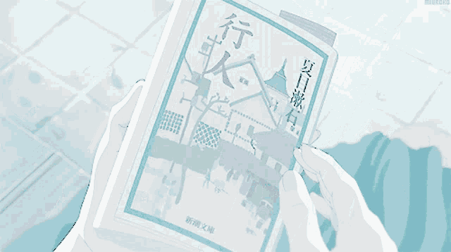 a person holding a book with chinese writing on the cover