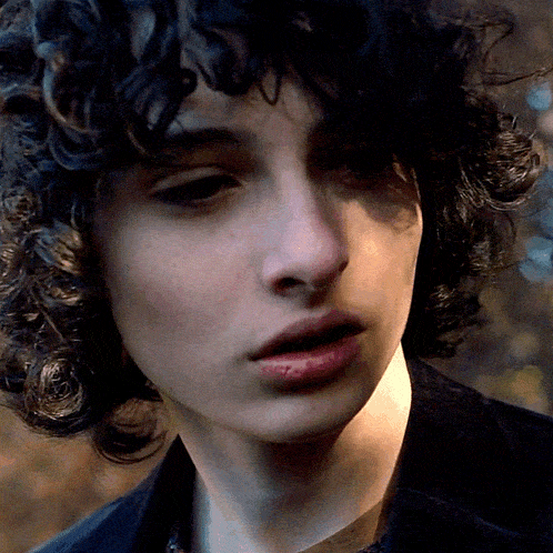 a close up of a person 's face with a black jacket on