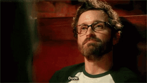 a man with a beard and glasses is saying dude