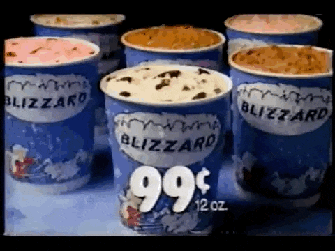 a bunch of cups of blizzard ice cream are sitting next to each other .