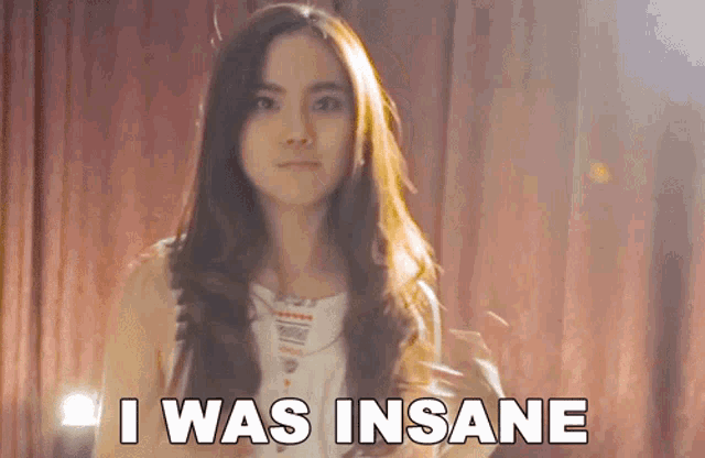 a woman says i was insane in front of a curtain