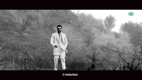 a black and white photo of a man in a suit with youtube music written on the bottom right