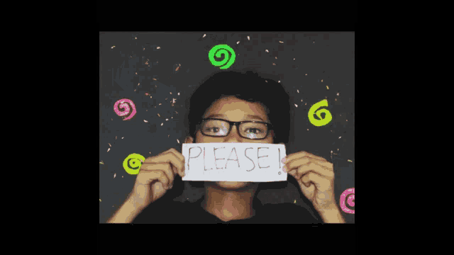 a boy with glasses holds a piece of paper that says please