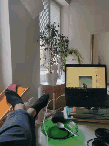 a person sitting at a desk with a laptop and a green mouse pad