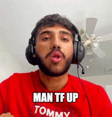 a man with a beard wearing headphones and a red shirt with the words `` man tf up tommy '' .