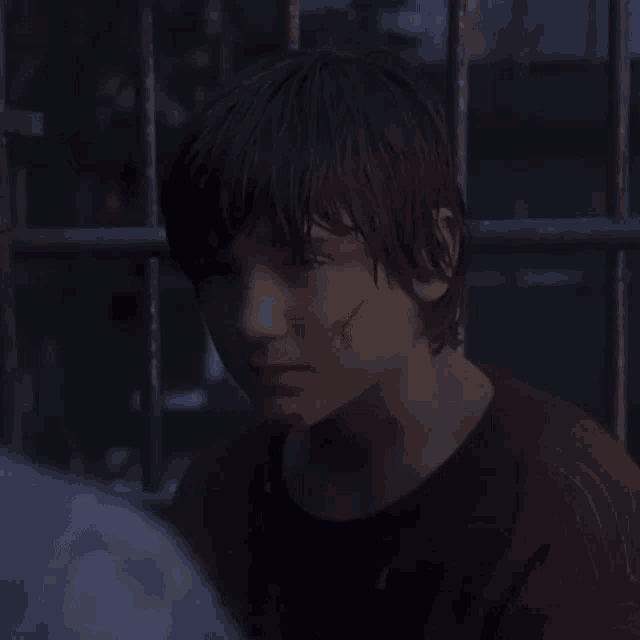 a boy with a scar on his neck is behind bars