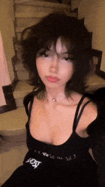 the girl is wearing a black dress and a choker necklace .