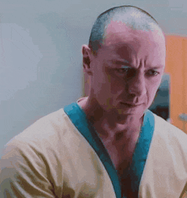 a man with a shaved head wearing a yellow shirt and a blue collar