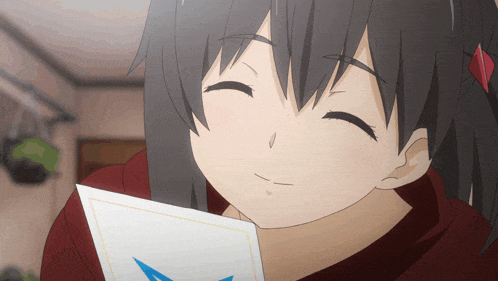 a girl with black hair is smiling and holding a piece of paper with a blue star on it