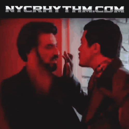 a man in a suit is walking down stairs with nycrhythm.com in the corner
