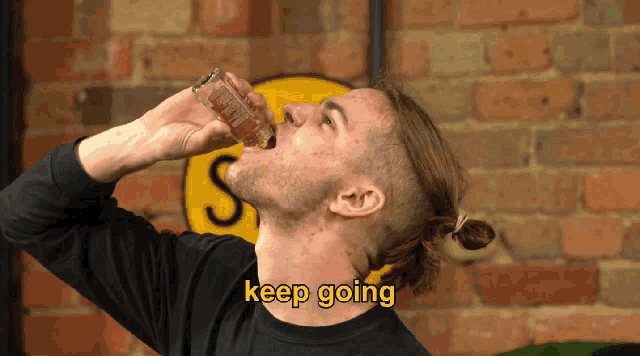a man is drinking from a shot glass with the words keep going written above him