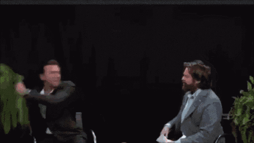 a man with a beard is wearing a suit and giving a speech .