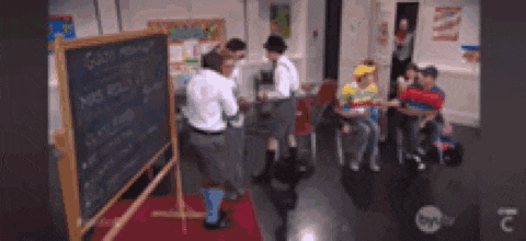 a group of people standing in front of a chalkboard that says goldfish