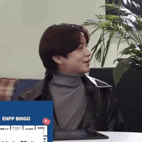 a man in a turtleneck sits in front of an enfp bingo advertisement