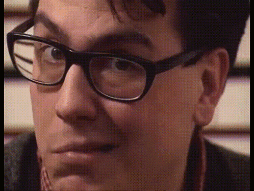 a close up of a person wearing glasses with a blurred background