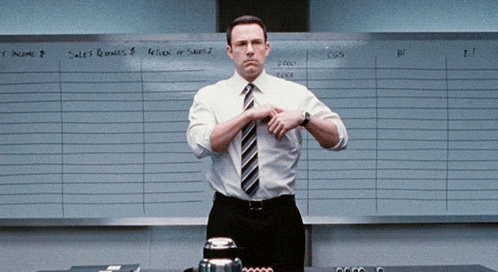 a man in a white shirt and tie is standing in front of a white board that says sales revenues