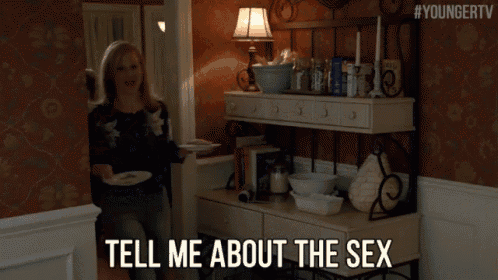 a woman in a floral shirt is holding a plate and says tell me about the sex