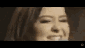 a close up of a woman 's face with her eyes closed in a dark room .