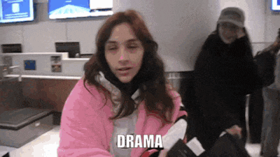 a woman in a pink jacket is holding a passport and the word drama is above her head