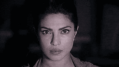 a close up of a woman 's face in a black and white photo with a blurred background .
