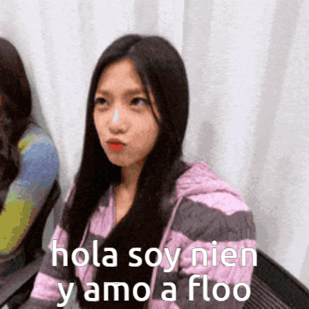a girl in a pink and gray striped sweater says hola soy nien y amo a floo .