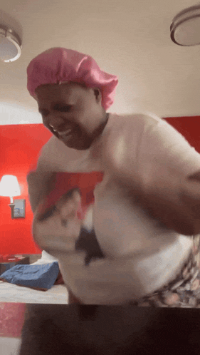a woman wearing a pink satin cap and a white shirt