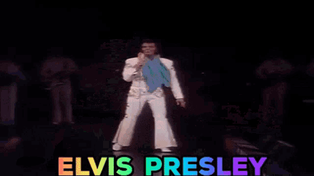 elvis presley is holding a microphone in front of him