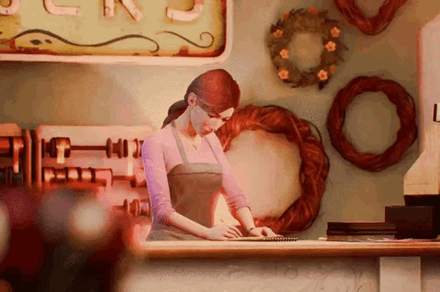 a woman in an apron sits at a counter in front of a sign that says j.