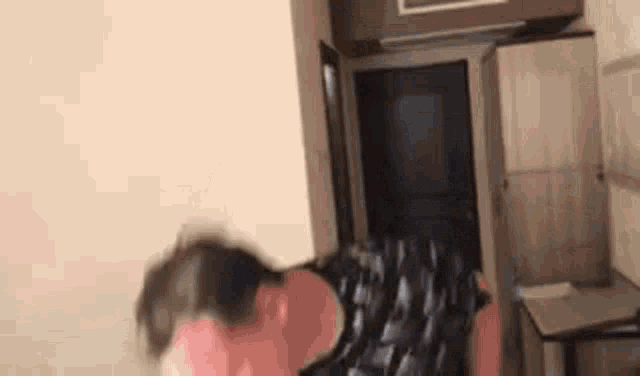 a person is standing in a room with a bag on the floor and a couch .