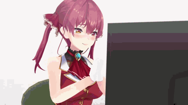 a girl with red hair is sitting in front of a monitor