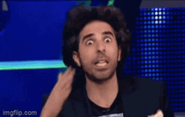 a man wearing headphones is making a surprised face in front of a blue background