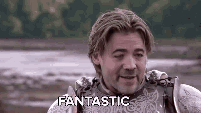 a man in a knight 's armor is saying fantastic in a field .