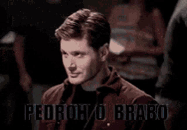 a man in a red jacket is standing in front of a sign that says ' i 'm not a fan '