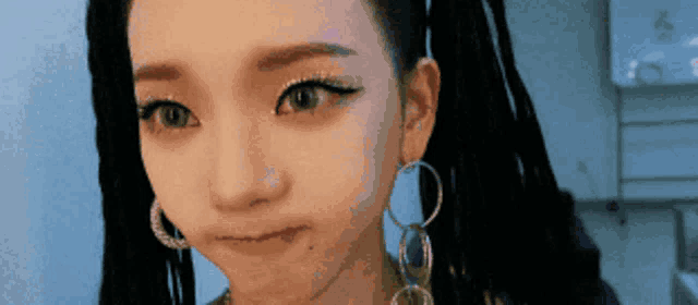 a close up of a woman wearing hoop earrings and pigtails
