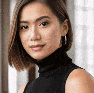 the woman is wearing a black turtleneck and hoop earrings