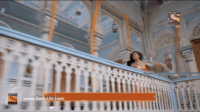 an ad for sony tv shows a woman dancing on a balcony